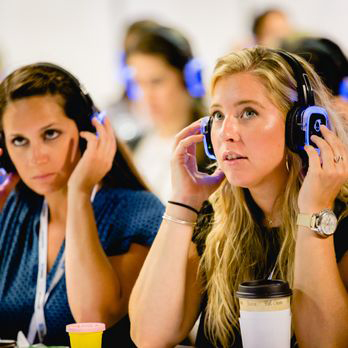 Asistentes ajustando sus auriculares de traducción simultánea