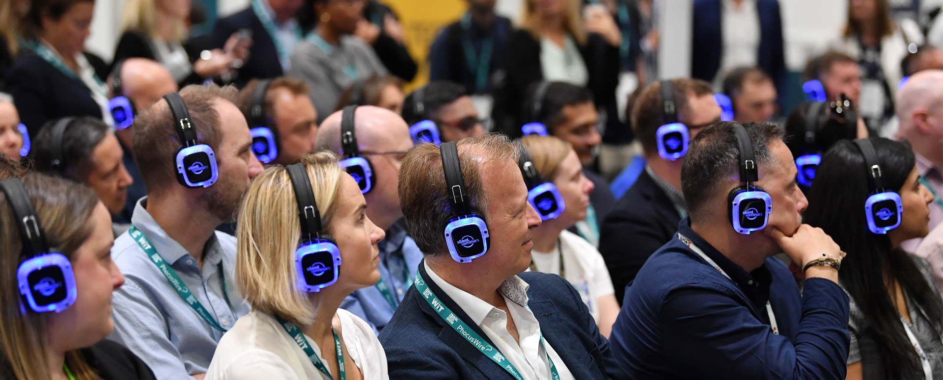 Asistentes escuchando con auriculares multicanal