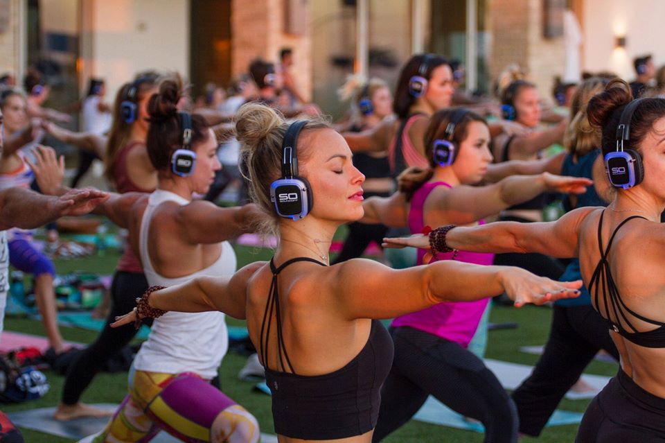 Clase colectiva de fitness con auriculares inalámbricos