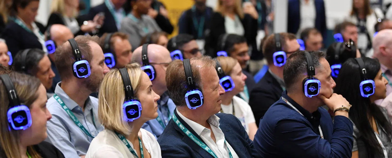Asistentes de congreso escuchando con auriculares multicanal