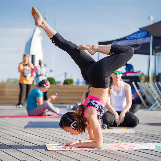 Práctica de yoga en terraza con auriculares silenciosos