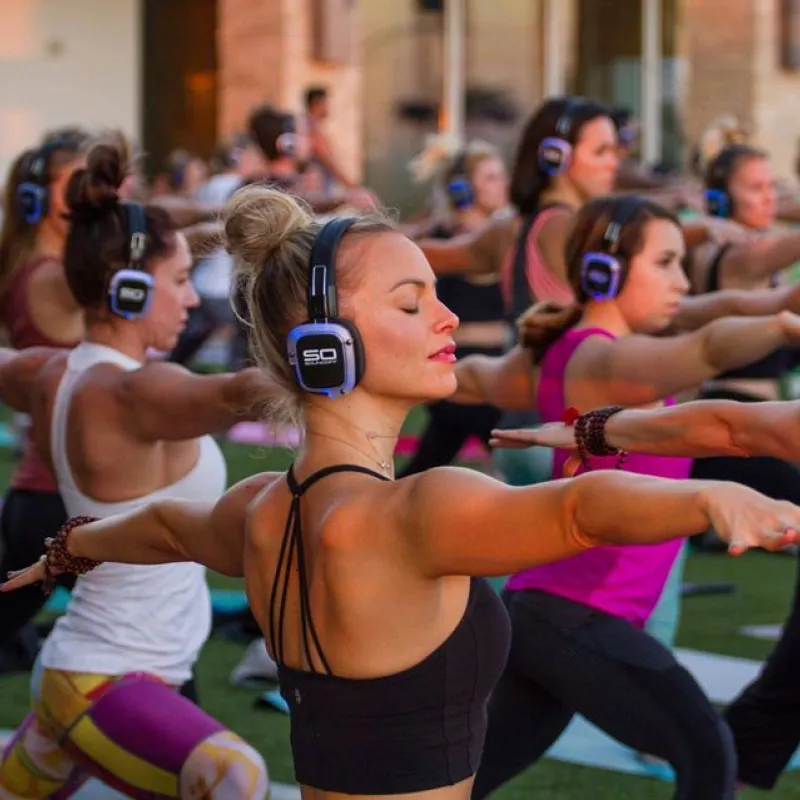 Clase colectiva de fitness con auriculares inalámbricos