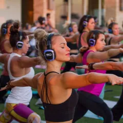 Clase colectiva de fitness con auriculares inalámbricos
