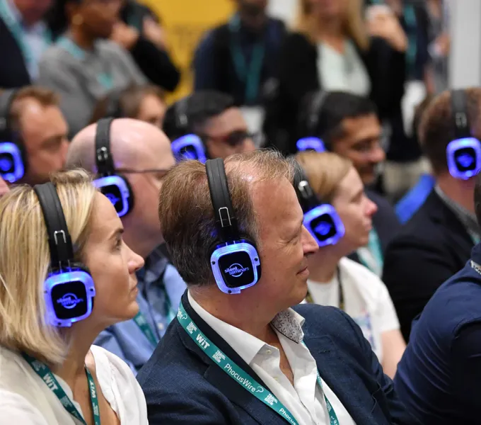 Asistentes de congreso escuchando con auriculares multicanal