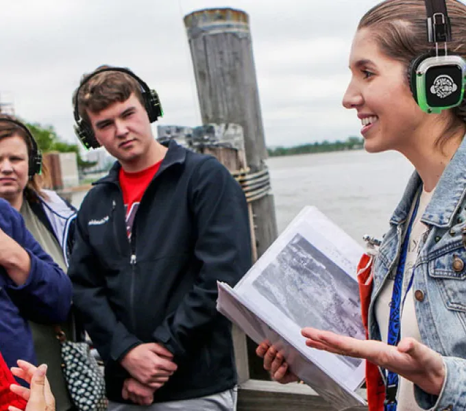 Guía turística explicando a un grupo con auriculares inalámbricos